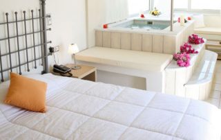569789bfcca2fdba2af671da-medium-3 Antinea Hotel - Junior Suite With Indoor Jacuzzi - Bedroom with Indoor Jacuzzi decorated with flowers