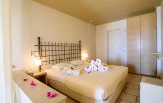 58ac2cb2ba941b27182c15db-large Antinea Hotel - Junior Suite With Outdoor Jacuzzi - Bed decorated with swan towels and flowers